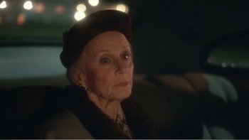 Movie still from “Driving Miss Daisy” (1989), directed by Bruce Beresford – An older woman sitting in a car at night; Close Up shot, Over the shoulder angle
