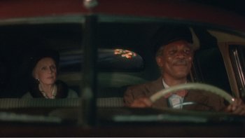 Movie still from “Driving Miss Daisy” (1989), directed by Bruce Beresford – A man and a woman sitting in the drivers seat of a car; Close Up shot, Over the shoulder angle