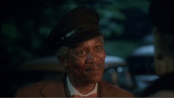 Movie still from “Driving Miss Daisy” (1989), directed by Bruce Beresford – An older man wearing a hat and a suit; Close Up shot, Over the shoulder angle