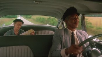 Movie still from “Driving Miss Daisy” (1989), directed by Bruce Beresford – A man sitting in the back seat of a car; Medium shot, Low angle