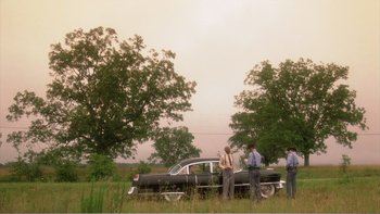 Movie still from “Driving Miss Daisy” (1989), directed by Bruce Beresford – A group of men standing next to an old car; Extreme Wide shot, Low angle
