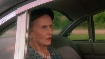 Movie still from “Driving Miss Daisy” (1989), directed by Bruce Beresford – An older woman sitting in the back seat of a car; Close Up shot, Over the shoulder angle