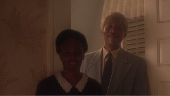 Movie still from “Driving Miss Daisy” (1989), directed by Bruce Beresford – A man and a woman standing next to each other in a room; Medium shot, Over the shoulder angle