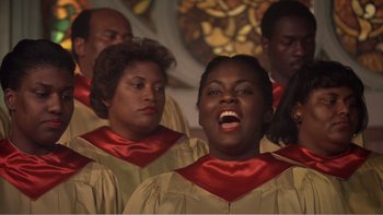 Movie still from “Driving Miss Daisy” (1989), directed by Bruce Beresford – A group of people singing in a choir; Close Up shot, High angle