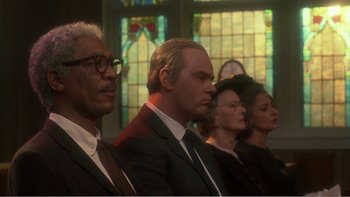 Movie still from “Driving Miss Daisy” (1989), directed by Bruce Beresford – A group of men and women sitting in front of a stained glass window; Close Up shot, Low angle