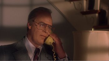 Movie still from “Driving Miss Daisy” (1989), directed by Bruce Beresford – An older man talking on a phone while wearing glasses; Close Up shot, Low angle