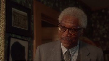 Movie still from “Driving Miss Daisy” (1989), directed by Bruce Beresford – An older man wearing a suit and tie; Close Up shot, Over the shoulder angle