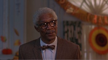 Movie still from “Driving Miss Daisy” (1989), directed by Bruce Beresford – An older man wearing a suit and bow tie; Close Up shot, Over the shoulder angle