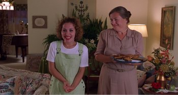Movie still from “Drop Dead Gorgeous” (1999), directed by Michael Patrick Jann – Two women standing next to each other in a living room; Medium shot, Over the shoulder angle