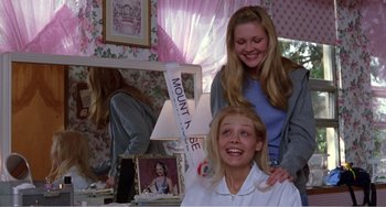 Movie still from “Drop Dead Gorgeous” (1999), directed by Michael Patrick Jann – Two young girls posing for a picture in front of a mirror; Medium shot, Low angle