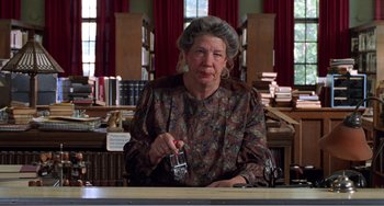 Movie still from “Drop Dead Gorgeous” (1999), directed by Michael Patrick Jann – An older woman sitting at a table in a library; Medium shot, Low angle