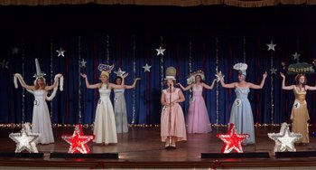 Movie still from “Drop Dead Gorgeous” (1999), directed by Michael Patrick Jann – A group of women on a stage performing a show; Wide shot, Low angle