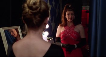 Movie still from “Drop Dead Gorgeous” (1999), directed by Michael Patrick Jann – A woman in a red dress looking in the mirror; Medium shot, Over the shoulder angle