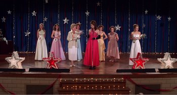 Movie still from “Drop Dead Gorgeous” (1999), directed by Michael Patrick Jann – A group of women on a stage wearing dresses; Wide shot, High angle
