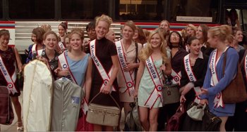 Movie still from “Drop Dead Gorgeous” (1999), directed by Michael Patrick Jann – A group of young women standing next to each other holding luggage; Wide shot, Low angle