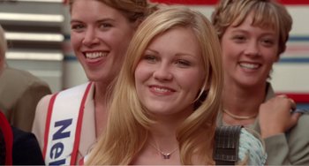 Movie still from “Drop Dead Gorgeous” (1999), directed by Michael Patrick Jann – A woman smiles for the camera with two other women; Close Up shot, Low angle