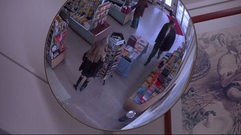 Movie still from “Drugstore Cowboy” (1989), directed by Gus Van Sant – A fisheye lens view of people shopping in a store; Wide shot, Overhead angle