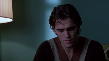 Movie still from “Drugstore Cowboy” (1989), directed by Gus Van Sant – A man with wet hair and a brown and white sweater; Close Up shot, Over the shoulder angle