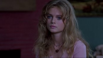 Movie still from “Drugstore Cowboy” (1989), directed by Gus Van Sant – A beautiful young woman with long blonde hair wearing a pink shirt; Close Up shot, Over the shoulder angle