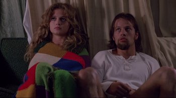 Movie still from “Drugstore Cowboy” (1989), directed by Gus Van Sant – A man and a woman sitting next to each other on a couch; Medium shot, Low angle