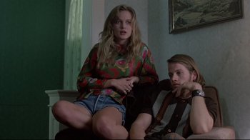 Movie still from “Drugstore Cowboy” (1989), directed by Gus Van Sant – A woman sitting next to a man on a couch; Medium shot, Low angle