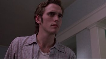 Movie still from “Drugstore Cowboy” (1989), directed by Gus Van Sant – A young man in a plaid shirt looking to his left; Close Up shot, Low angle