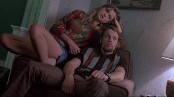 Movie still from “Drugstore Cowboy” (1989), directed by Gus Van Sant – A man and a woman sitting on a couch together; Medium shot, High angle