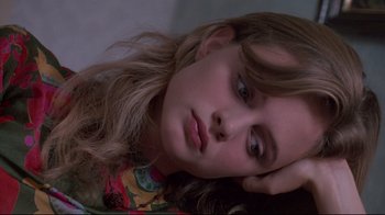 Movie still from “Drugstore Cowboy” (1989), directed by Gus Van Sant – A woman with long hair is laying down; Close Up shot, Over the shoulder angle