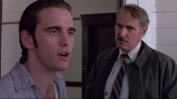 Movie still from “Drugstore Cowboy” (1989), directed by Gus Van Sant – A man in a suit and tie next to another man in a suit and tie; Close Up shot, Over the shoulder angle