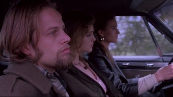 Movie still from “Drugstore Cowboy” (1989), directed by Gus Van Sant – A man and two women sitting in the back of a car; Close Up shot, Low angle