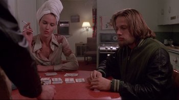 Movie still from “Drugstore Cowboy” (1989), directed by Gus Van Sant – A man and woman sitting at a table playing cards; Medium shot, Over the shoulder angle