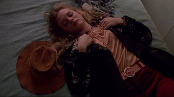 Movie still from “Drugstore Cowboy” (1989), directed by Gus Van Sant – A woman laying on the ground with her eyes closed; Medium shot, Overhead angle