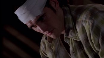 Movie still from “Drugstore Cowboy” (1989), directed by Gus Van Sant – A man wearing a bandage on his head; Close Up shot, Low angle