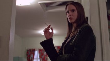 Movie still from “Drugstore Cowboy” (1989), directed by Gus Van Sant – A woman holding a cigarette in her hand; Close Up shot, Low angle