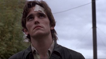 Movie still from “Drugstore Cowboy” (1989), directed by Gus Van Sant – A man with a bandage on his forehead; Close Up shot, Low angle
