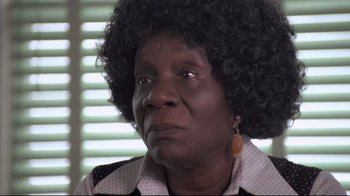 Movie still from “Drugstore Cowboy” (1989), directed by Gus Van Sant – An older black woman with a large afro looking to her left; Close Up shot, Low angle