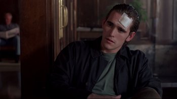 Movie still from “Drugstore Cowboy” (1989), directed by Gus Van Sant – A man with a bandage on his forehead; Close Up shot, Over the shoulder angle