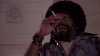 Movie still from “Drugstore Cowboy” (1989), directed by Gus Van Sant – A man holding a cigarette in his hand; Close Up shot, Low angle