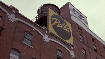 Movie still from “Drugstore Cowboy” (1989), directed by Gus Van Sant – A building that has a sign on the side of the building; Extreme Wide shot, Low angle