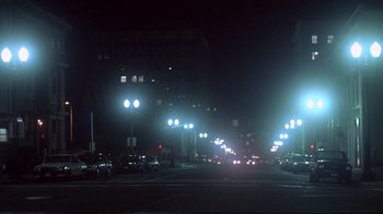 Movie still from “Drugstore Cowboy” (1989), directed by Gus Van Sant – A street filled with lots of traffic lights at night; Extreme Wide shot, Low angle