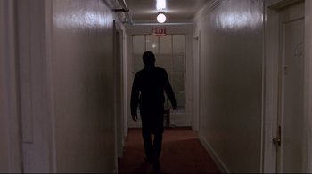 Movie still from “Drugstore Cowboy” (1989), directed by Gus Van Sant – A man walking down a hallway in a building; Wide shot, Low angle