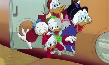 Movie still from “DuckTales the Movie: Treasure of the Lost Lamp” (1990), directed by Bob Hathcock – A group of cartoon characters are gathered around a mirror; Medium shot, Low angle