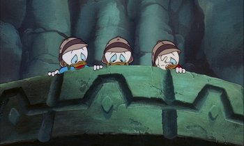 Movie still from “DuckTales the Movie: Treasure of the Lost Lamp” (1990), directed by Bob Hathcock – A group of three cartoon characters looking over a wall; Medium shot, Low angle