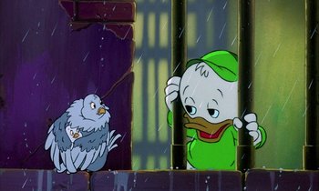 Movie still from “DuckTales the Movie: Treasure of the Lost Lamp” (1990), directed by Bob Hathcock – A duck and a bird are in a cage in the rain; Medium shot, Low angle