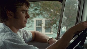 Movie still from “The Paperboy” (2012), directed by Lee Daniels – A young man driving a car in the back of a car; Close Up shot, Over the shoulder angle