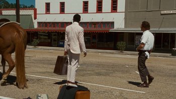 Movie still from “The Paperboy” (2012), directed by Lee Daniels – A man walking down the street with his suitcases; Wide shot, High angle