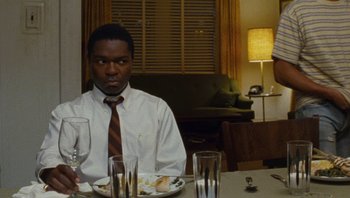 Movie still from “The Paperboy” (2012), directed by Lee Daniels – A man sitting at a table with a plate in front of him; Medium shot, Over the shoulder angle