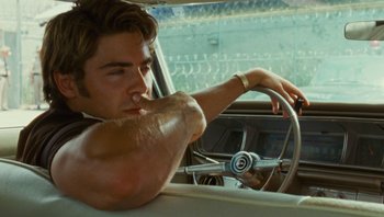 Movie still from “The Paperboy” (2012), directed by Lee Daniels – A man sitting in the driver's seat of a car; Medium shot, Over the shoulder angle