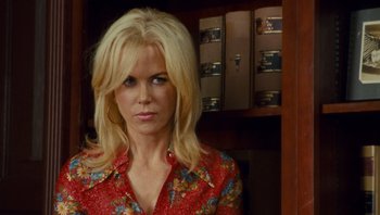 Movie still from “The Paperboy” (2012), directed by Lee Daniels – A woman with blonde hair wearing a red floral shirt; Close Up shot, Over the shoulder angle