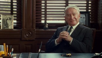 Movie still from “The Paperboy” (2012), directed by Lee Daniels – An older man sitting at a table in front of a window; Medium shot, Over the shoulder angle